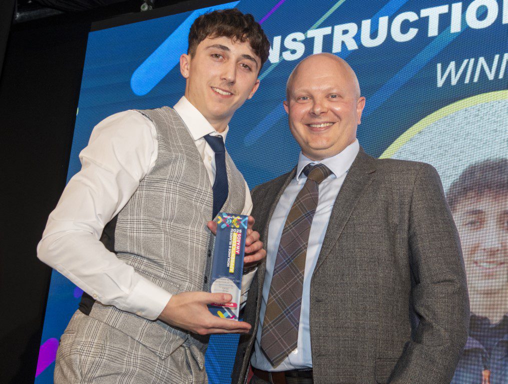 Apprentice Kai receiving an award on stage Apprentice Kai receiving an award on stage