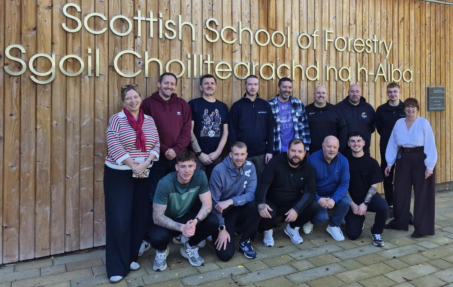 A group of employees on a commercial course and two lecturers standing outside