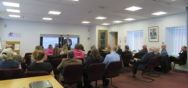 People sitting in a conference room listening to a presenter