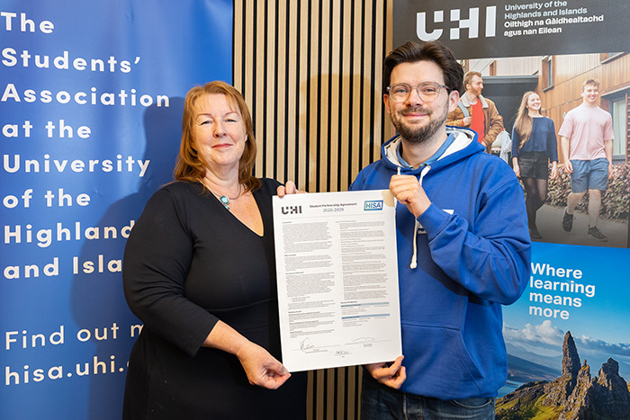 Two people holding a signed agreement