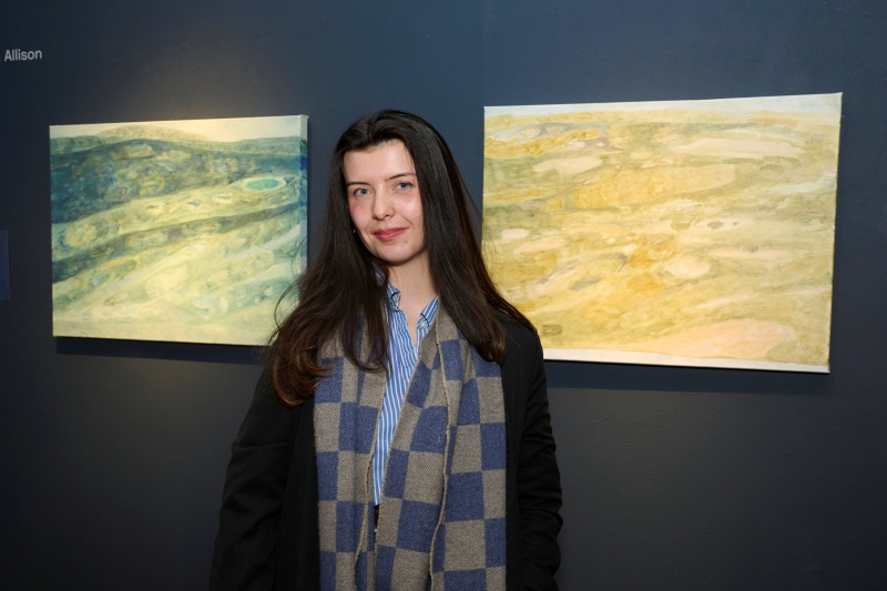 Caitlin Allison standing in front of artword