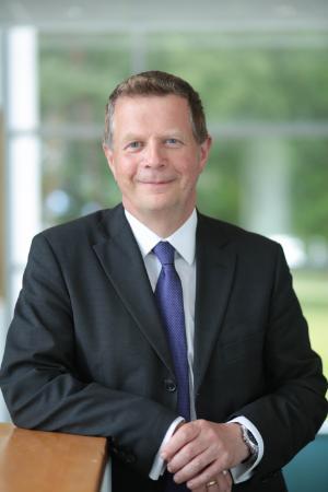 Man wearing a suit and tie looking at the camera