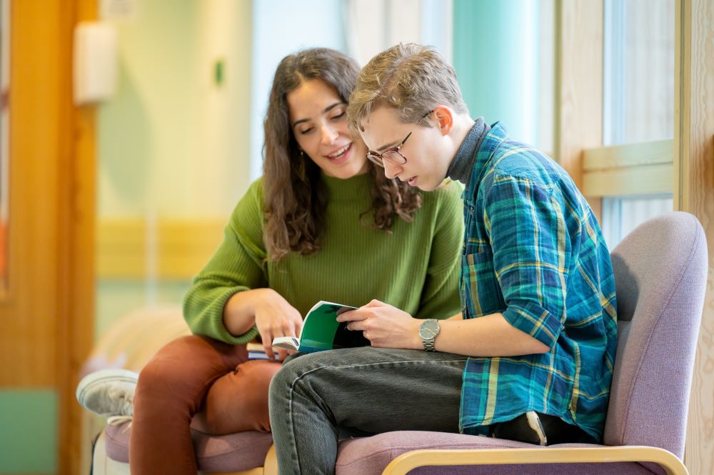 A photograph of two students discussing text